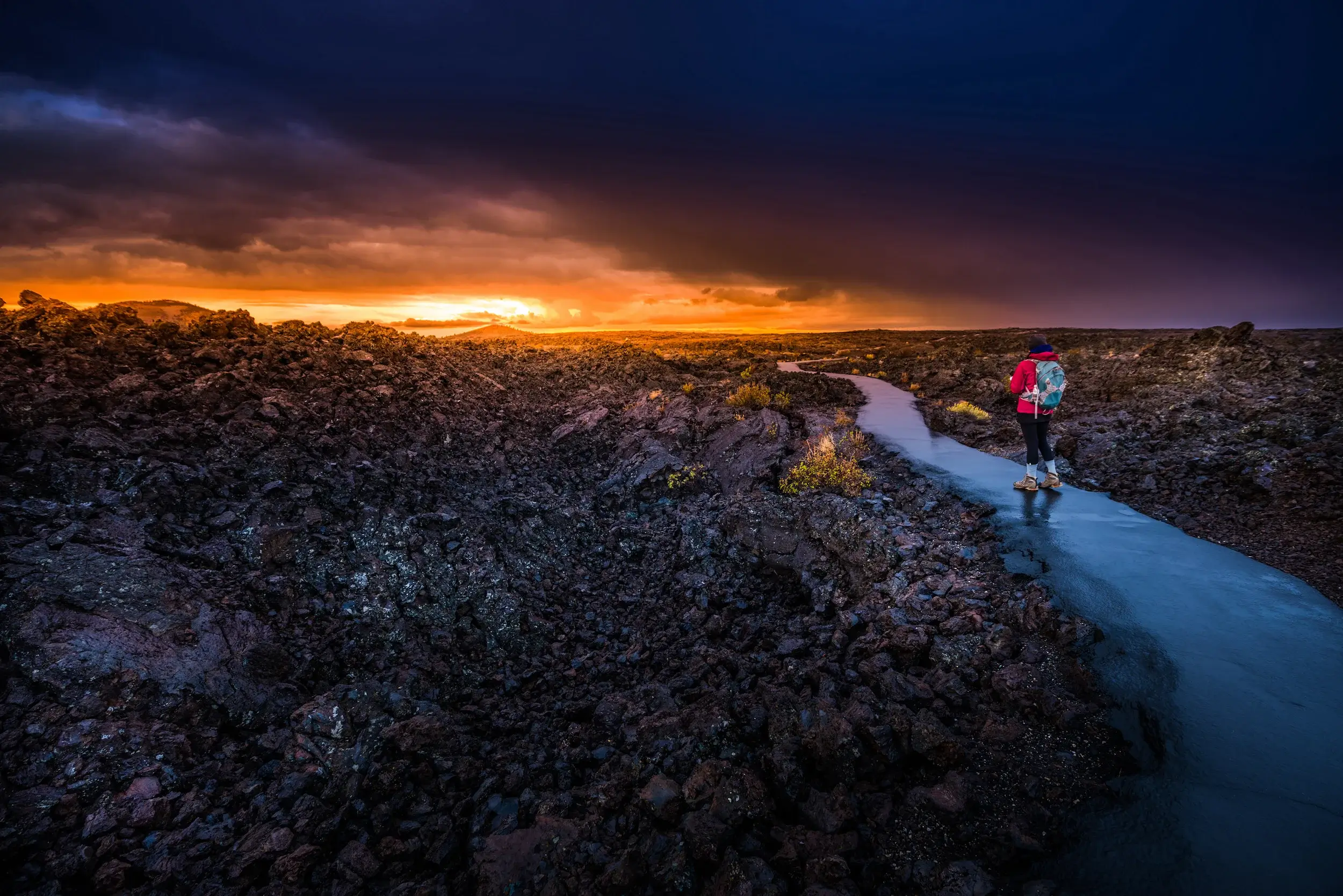 Hiker Backpacker on a trail Craters of The Moon National Monument Idaho. How to book an American road trip?